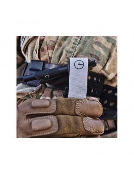 mão com luvas militar a segurar um Torniquete SAM XT